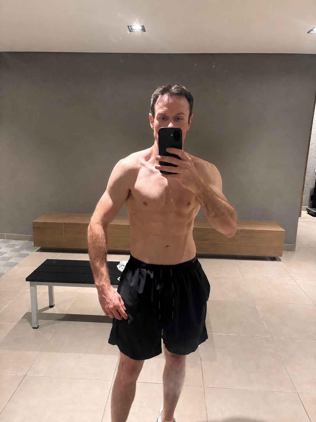 John further into his journey, taking a mirror selfie in a gym changing room.